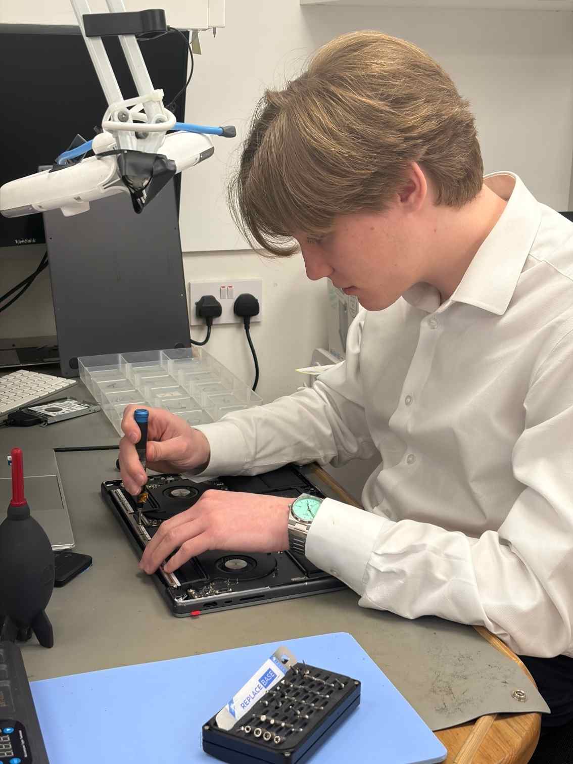Person repairing a laptop in a technical setting